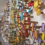 Drwings suspended from teh wall on cardboard splints.